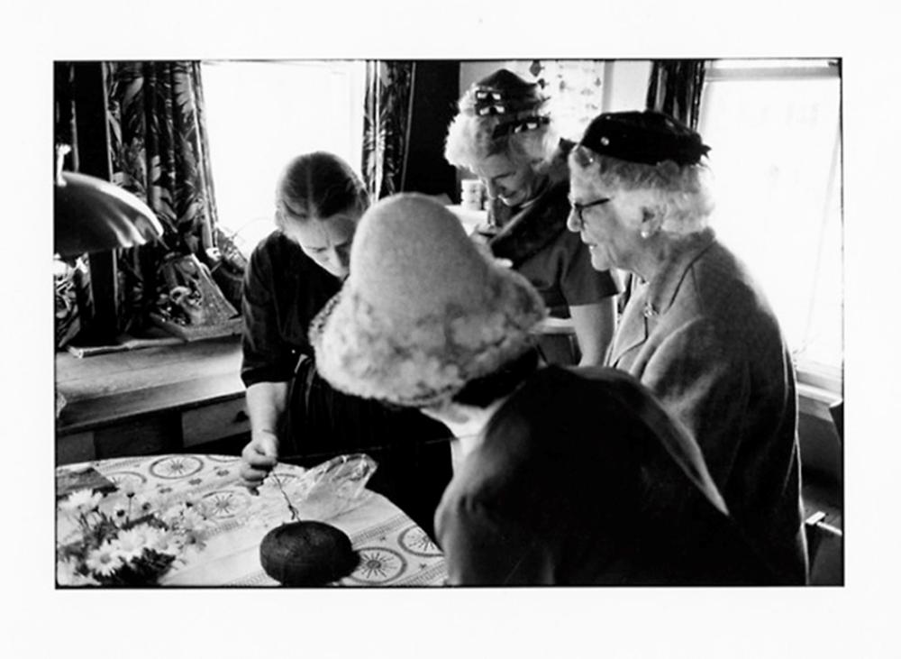 elizabeth zimmermann demonstrating use of icelandic unspun wool to hatted ladies at a wedding reception